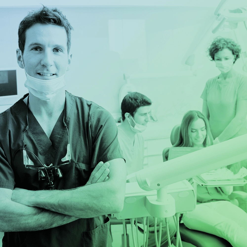 Dentist portrait with background of patient and assistants