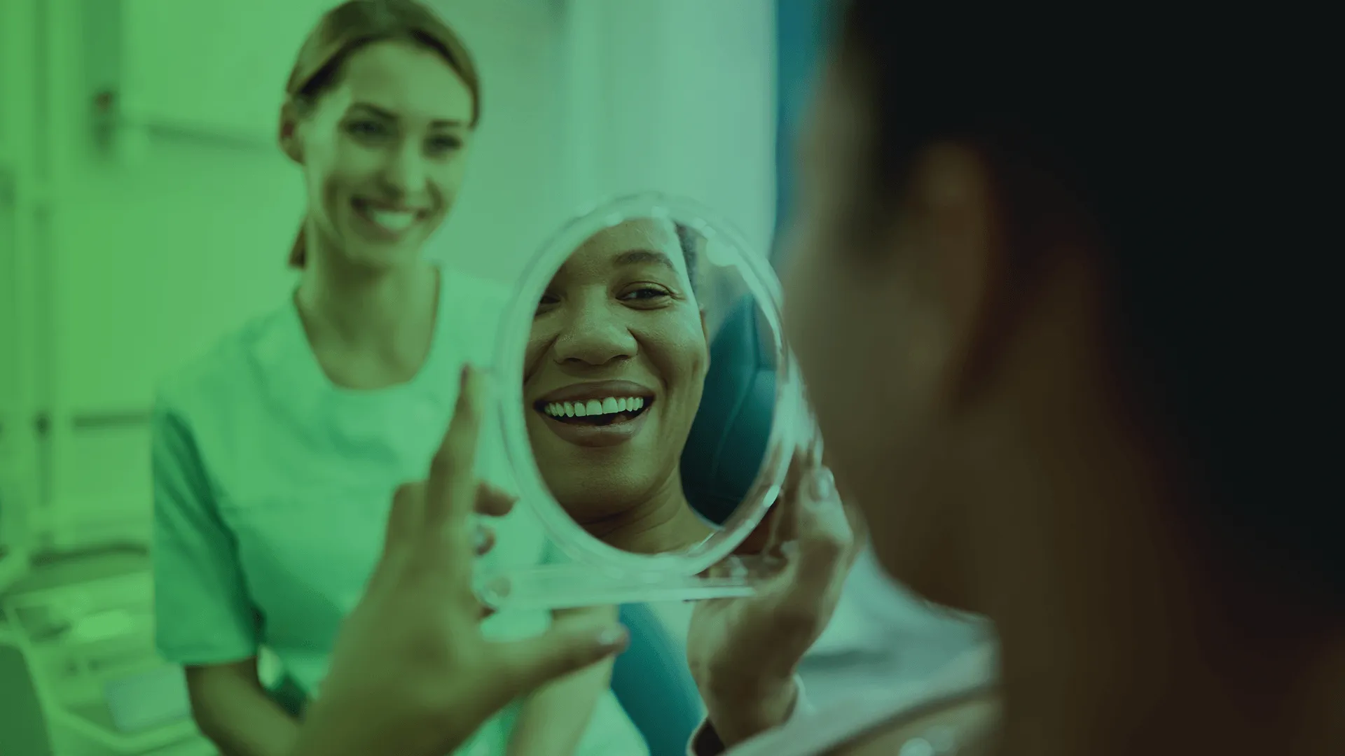 Patient looking in mirror and dentist in background