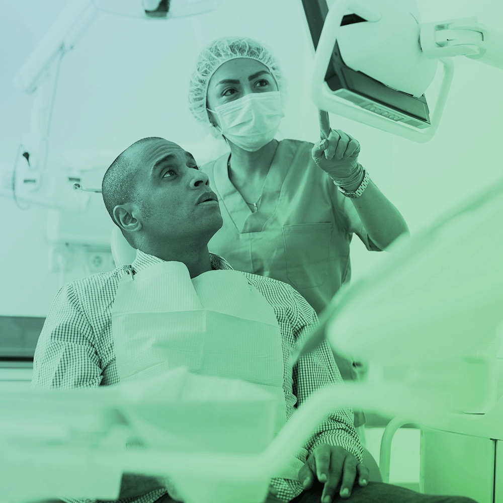 Dentist showing something to patient on screen