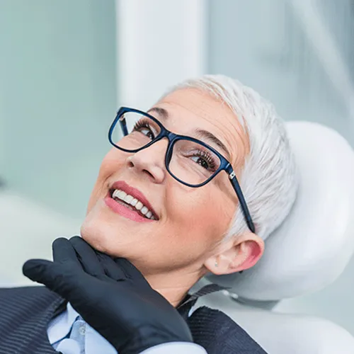 gloved hand lifting the chin of smiling woman